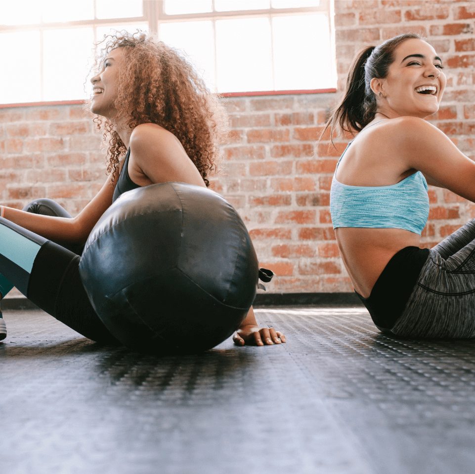 two women working out with a medicine ball